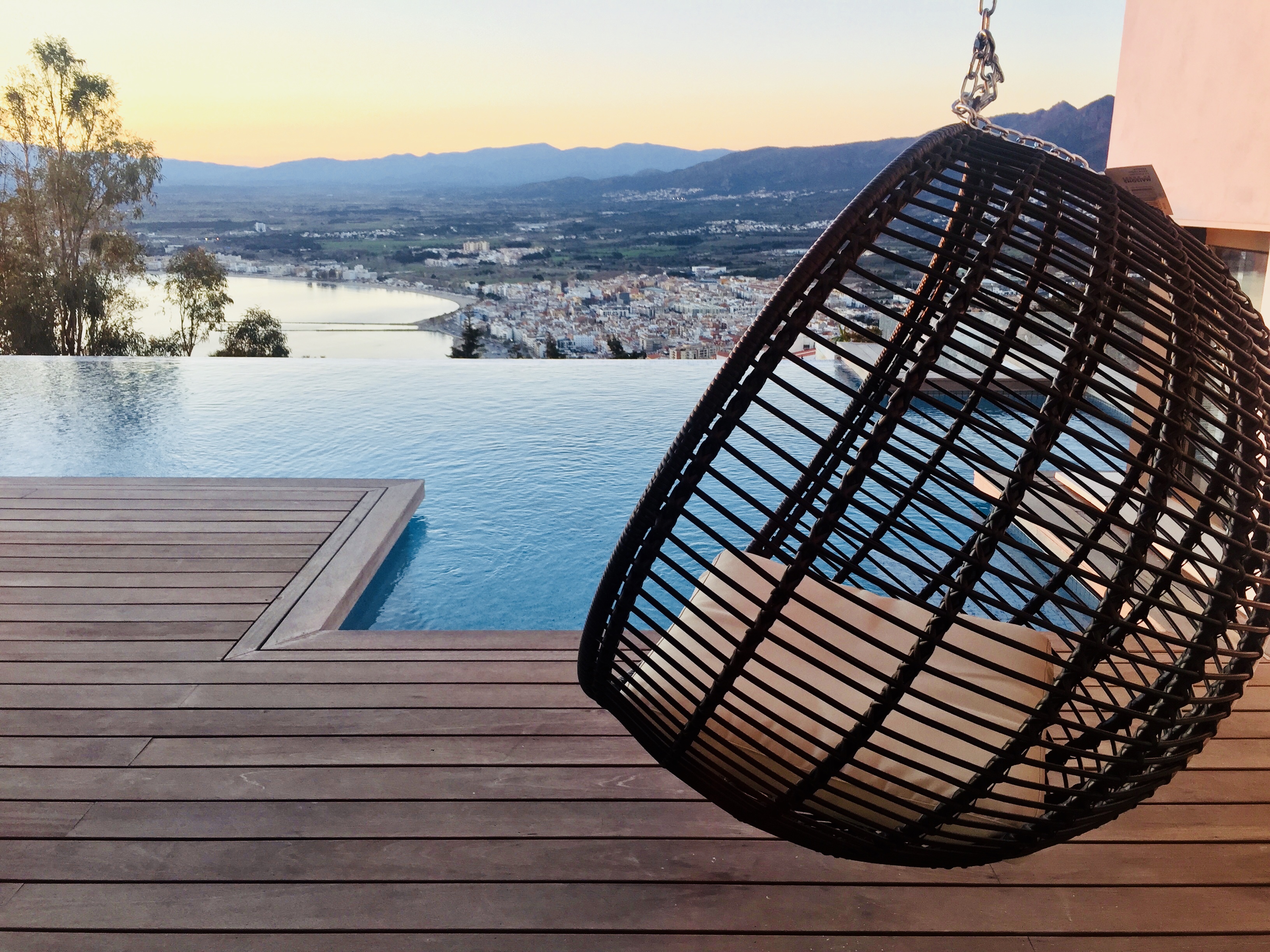 Infinity pool with hanging chair overlooking Roses bay and mountains